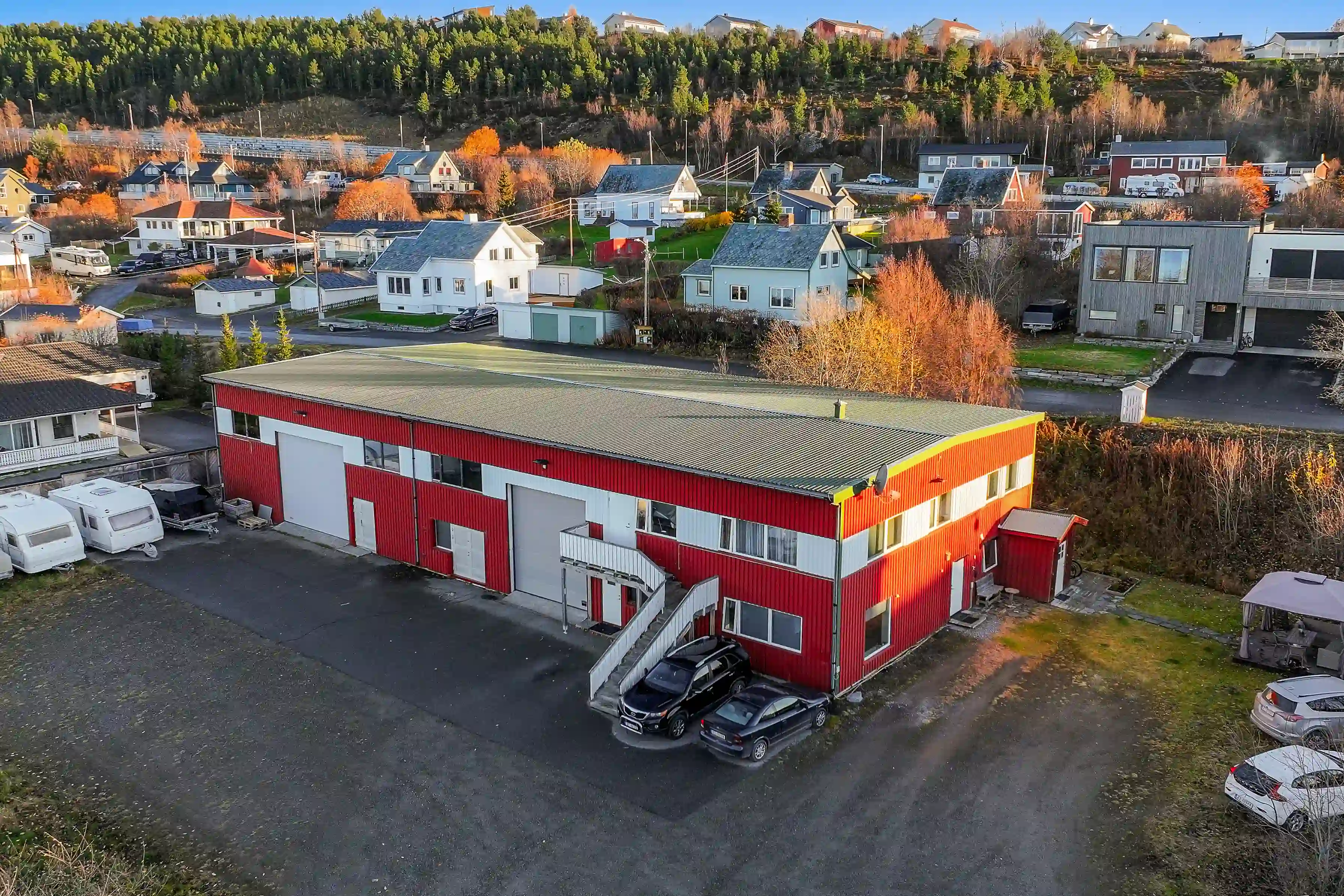 Rødt og hvitt næringsbygg omringet av bebyggelse