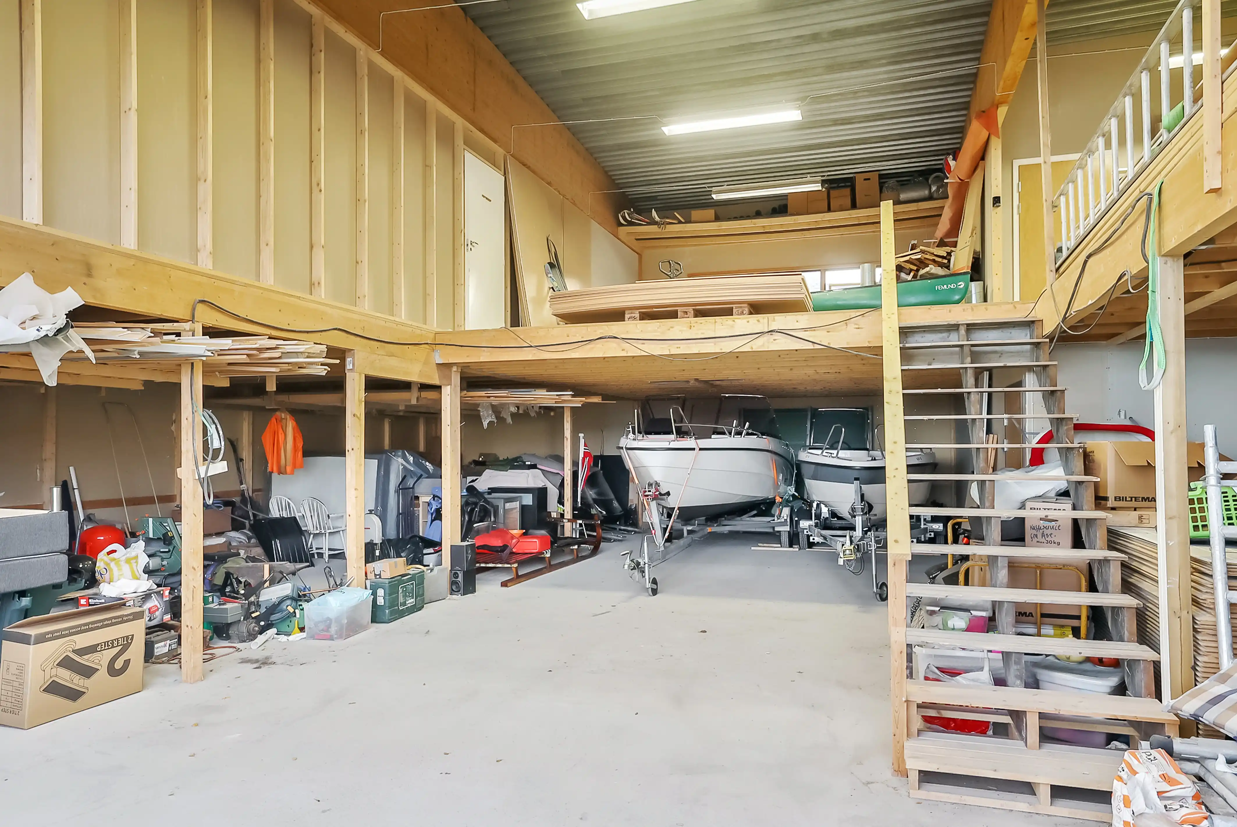 Lagringshall med båter på tilhengere og loft for ekstra oppbevaring.